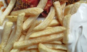 Portion Currywurst mit Pommes und Mayonnaise von der evangelischen Pommesbude „Pommes Goldgelb“ in Verden.